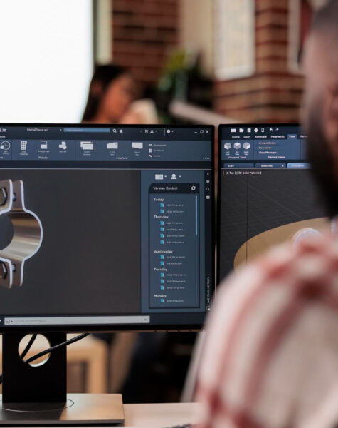 A man sitting in front of two computer monitors.