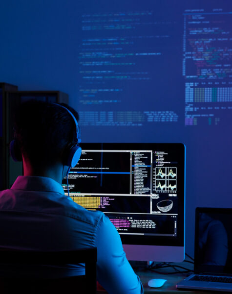 A man sitting in front of a computer screen.