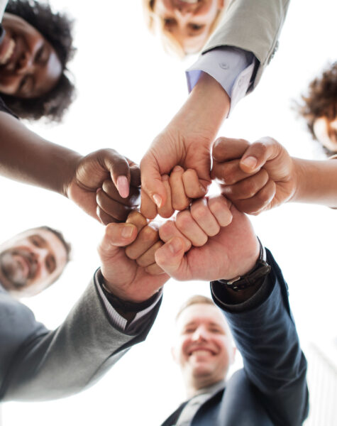 A group of people holding hands in the middle of a circle.